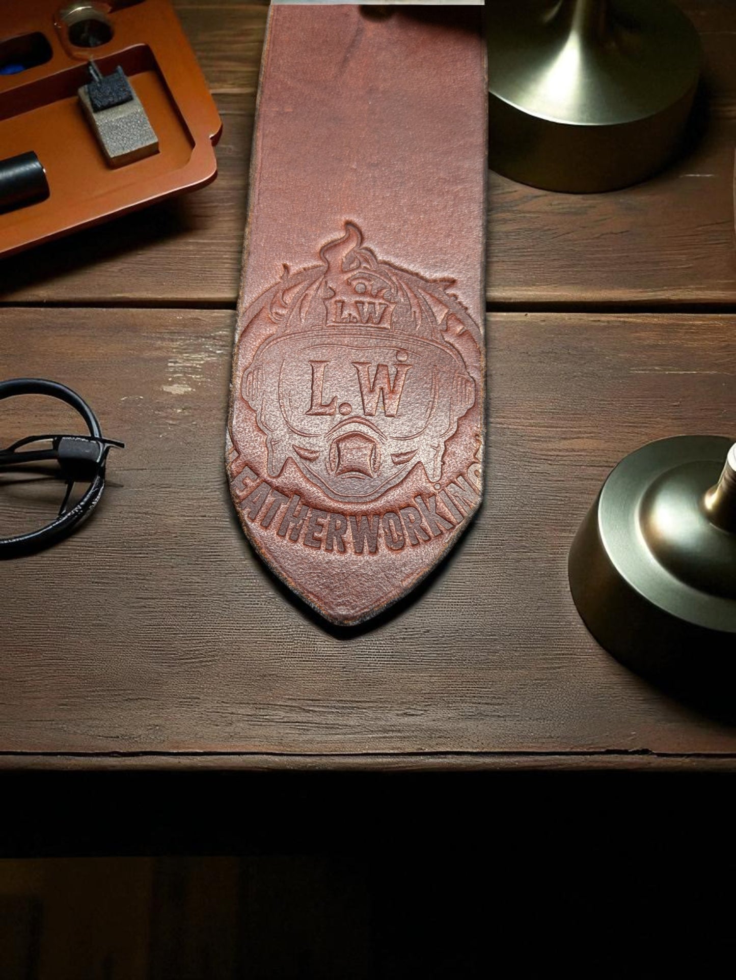 An Image of a Brown leather belt tail end with the Lwleatherworking Maker's Mark.