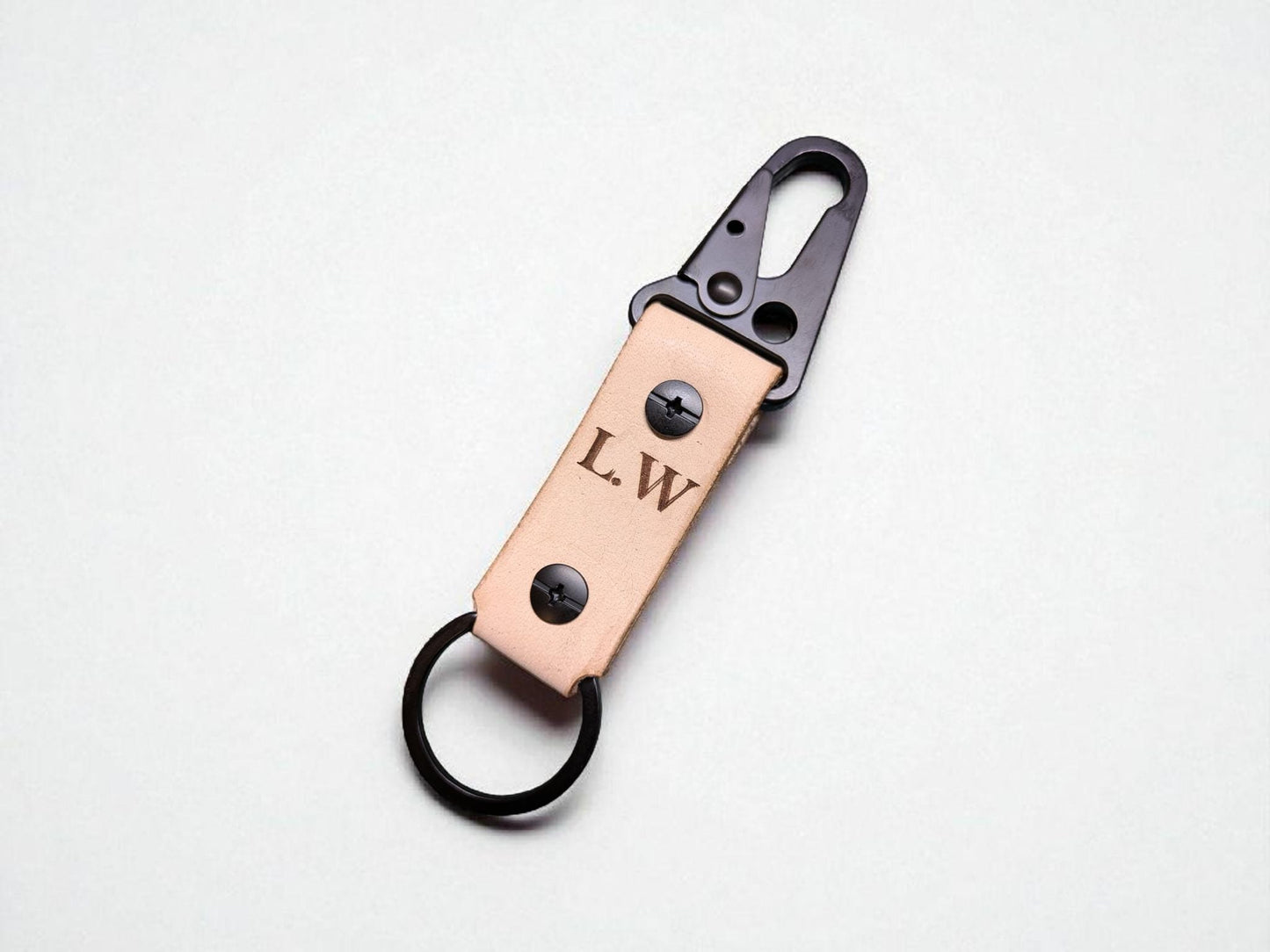 Leather keychain with metal clip and initials 'L.W.' on a light gray background