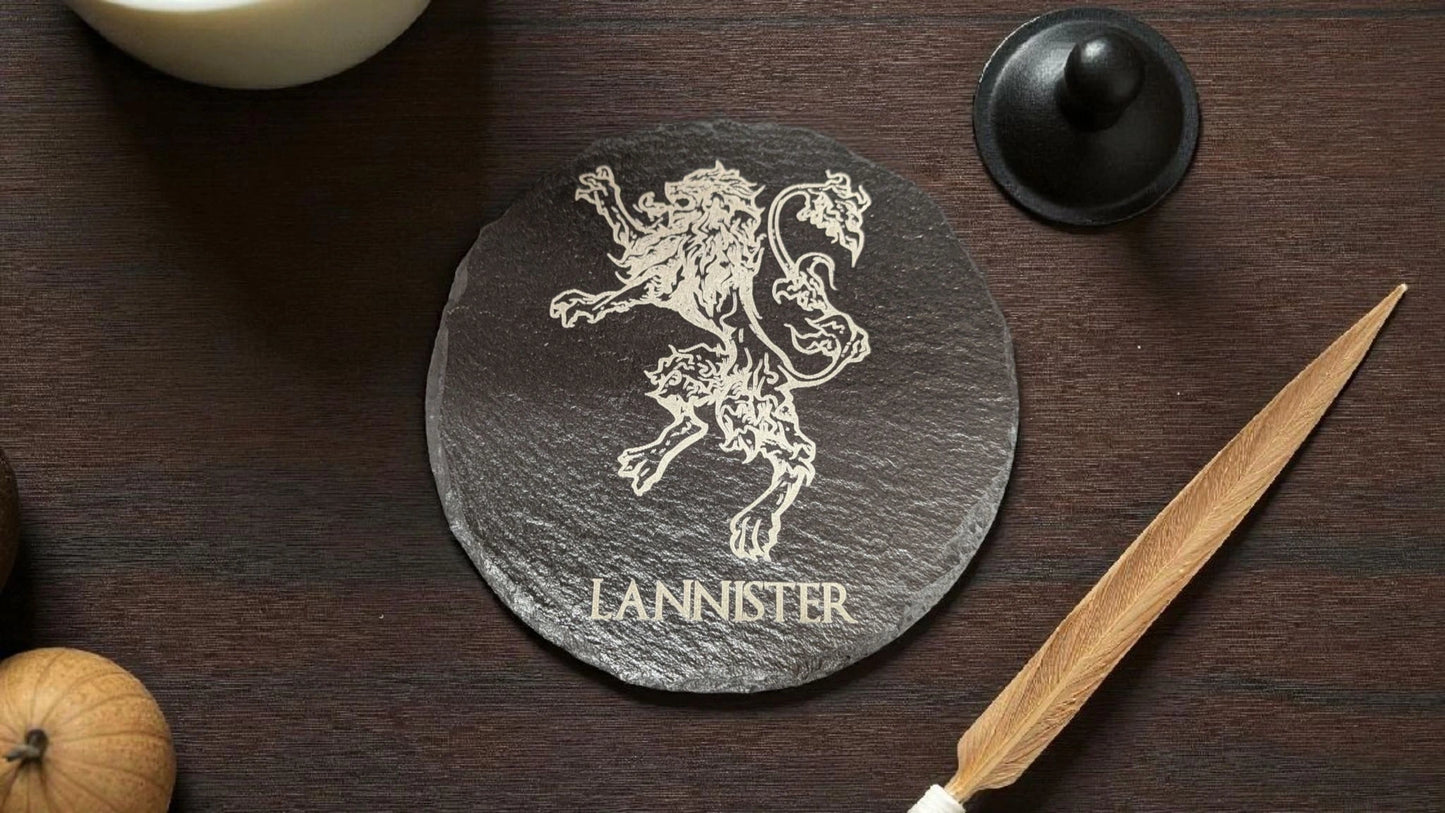 Slate coaster with a lion emblem and 'Lannister' text on a wooden surface.