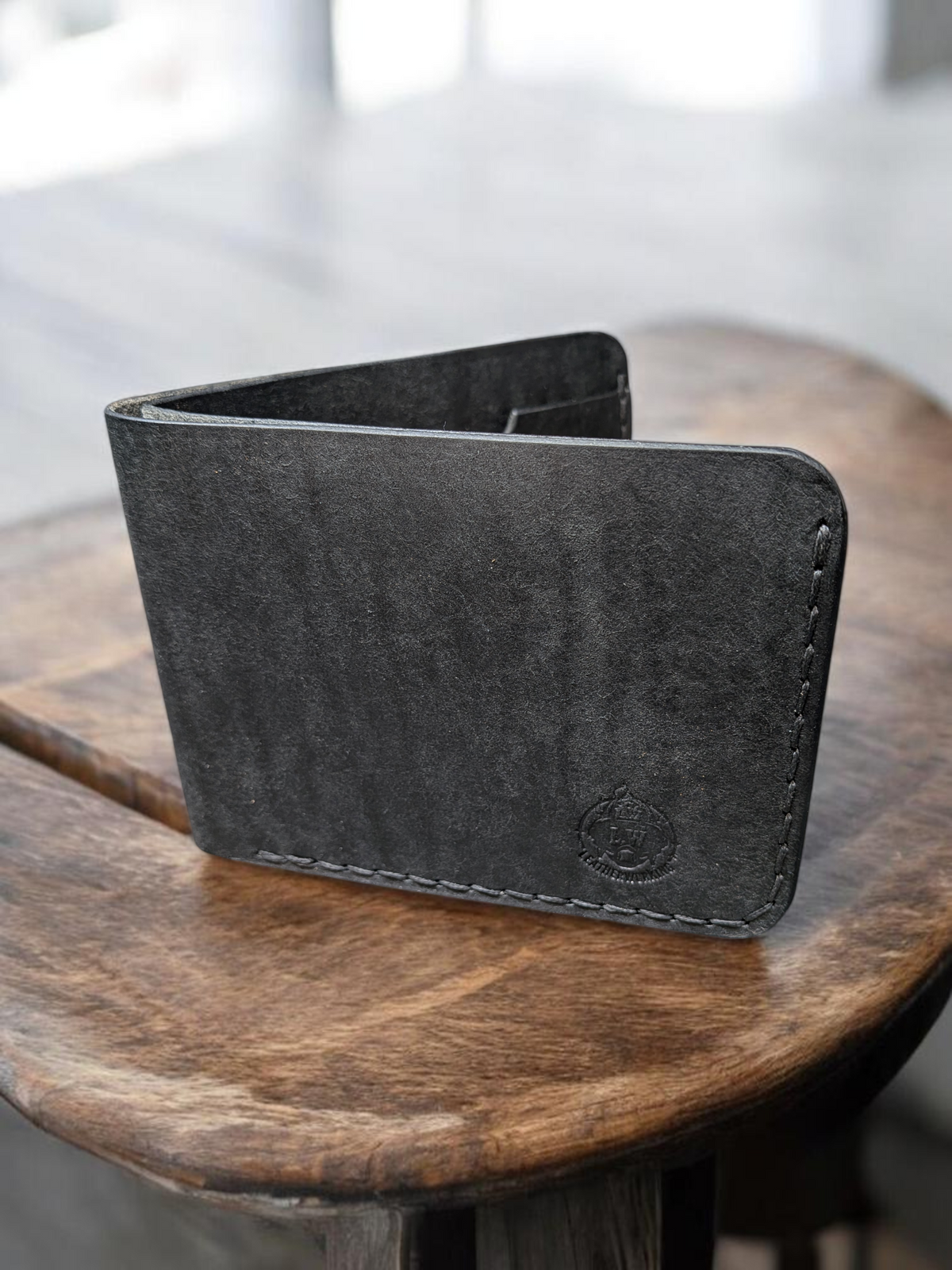 Mealstrom bifold wallet in black Badalassi Pueblo leather with grey stitching and embossed logo