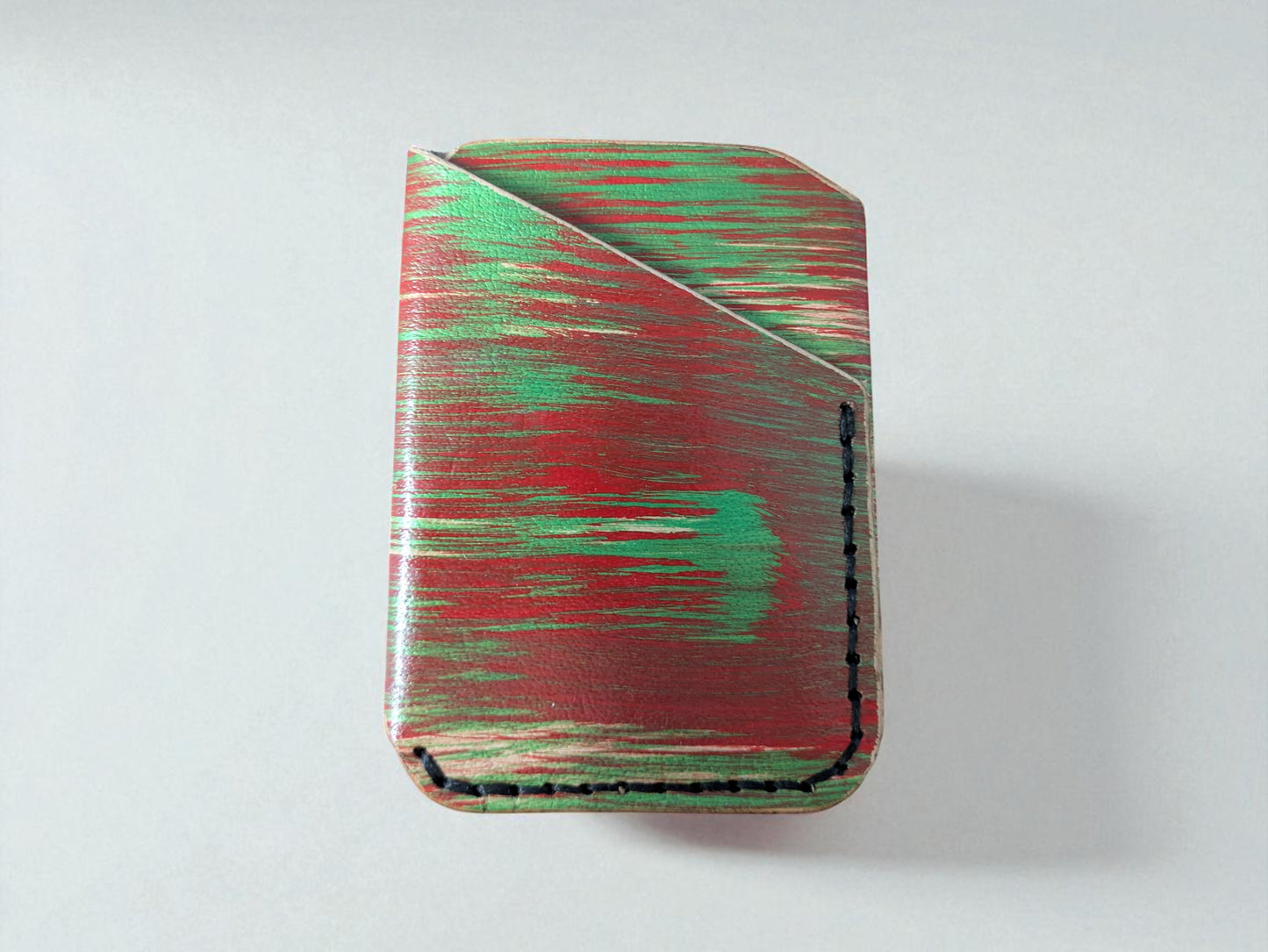 Rectangular cardholder with red and green abstract pattern on a white background