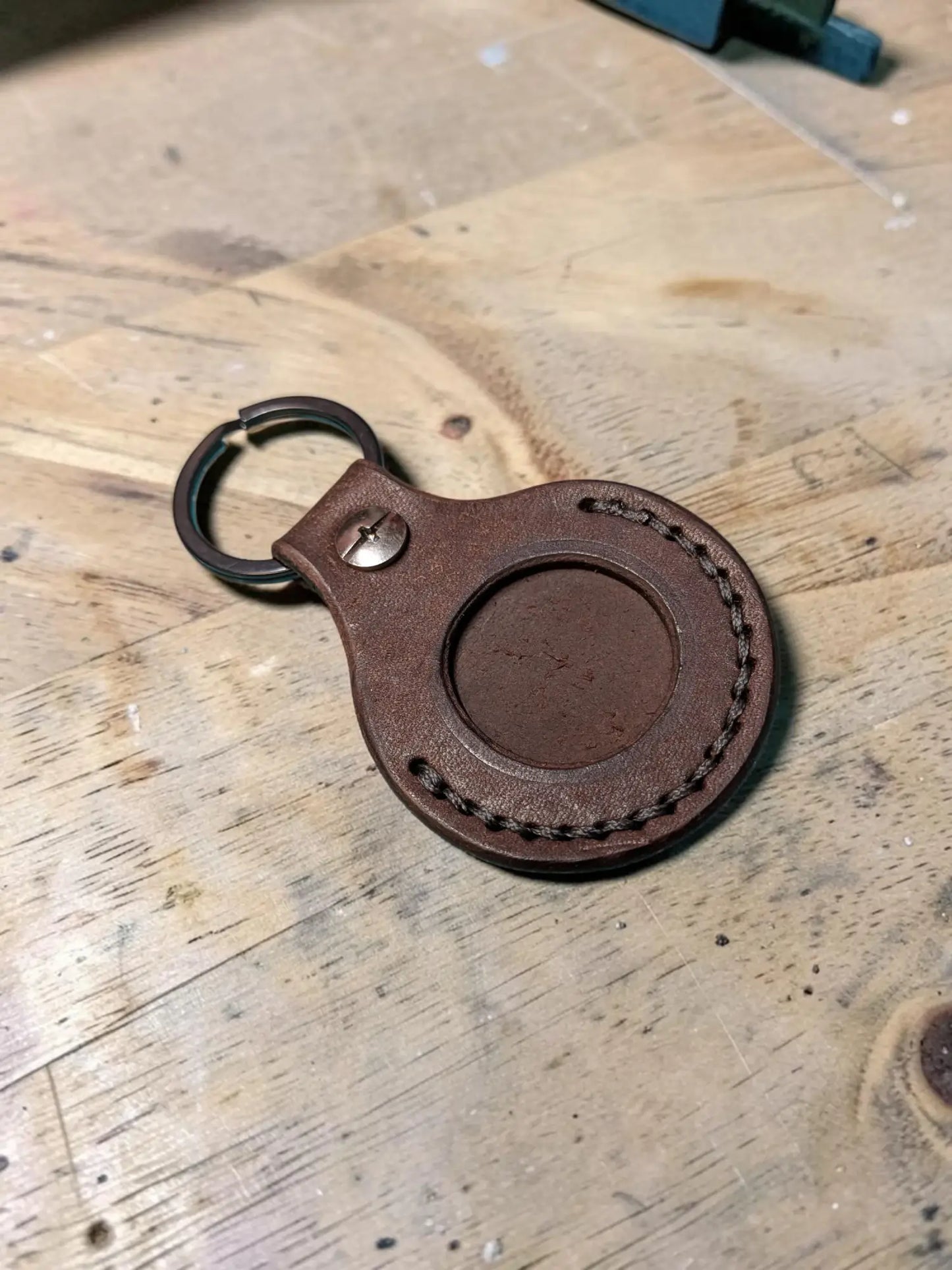 Brown leather badalassi pueblo airtag keychain with circular cutout and stitched edges for everyday carry use