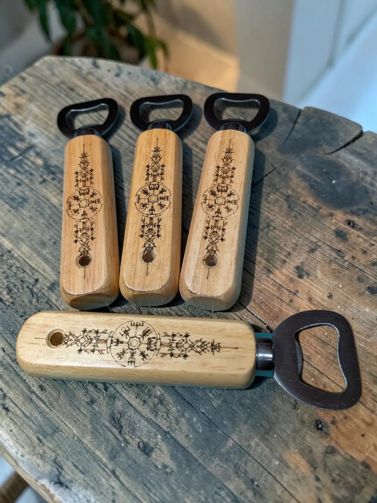 Set of four engraved viking rune wooden bottle openers with intricate black metal pull tabs for bar use