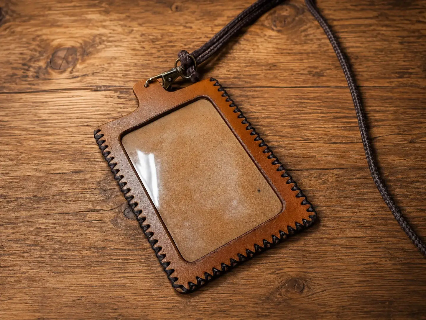 Brown full grain leather id holder with clear plastic window stitched edges and lanyard holder