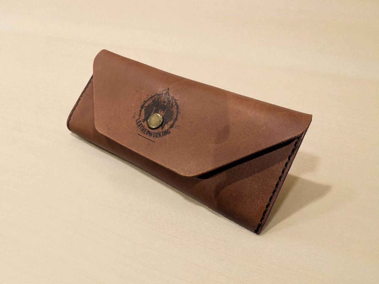 Brown leather Sunglasses Case with a brand logo on a beige background