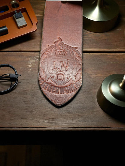 An Image of a Brown leather belt tail end with the Lwleatherworking Maker's Mark.