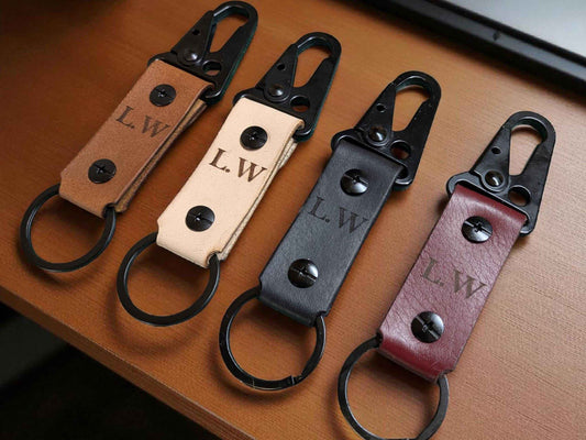 Four Customised Tactical Leather Keychains displayed on a mid brown tabletop