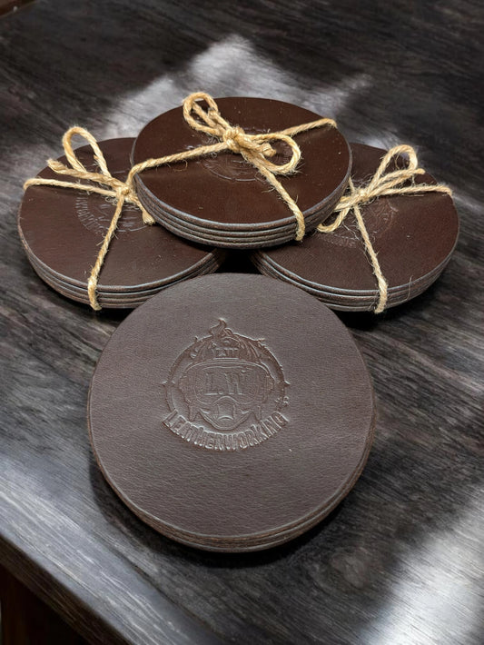 Set of four round dark brown full grain leather drinks coasters stamped with the LwLeatherworking logo