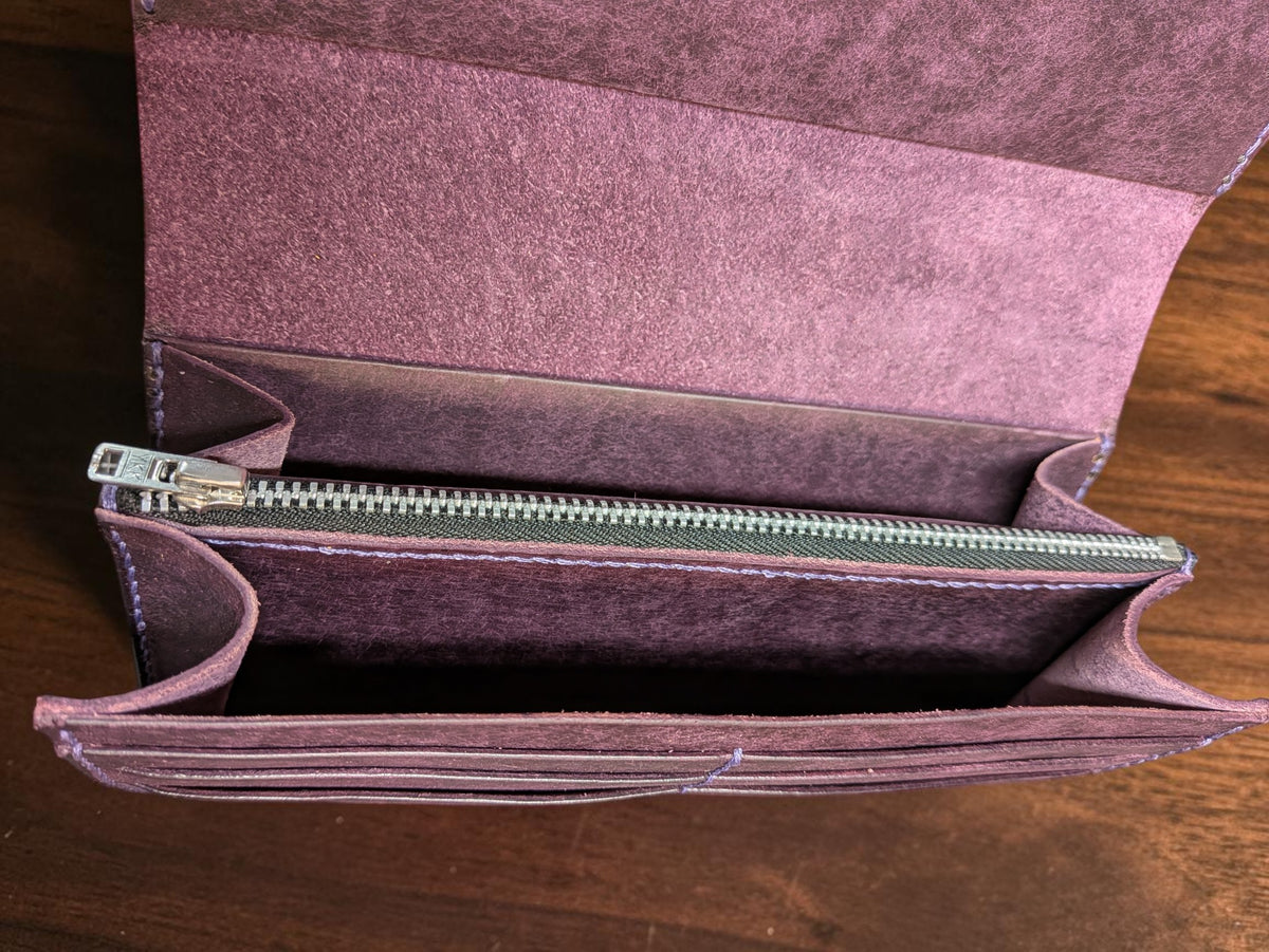 Inside the purple leather long wallet showing the zipped coin pouch and gusseted note compartments