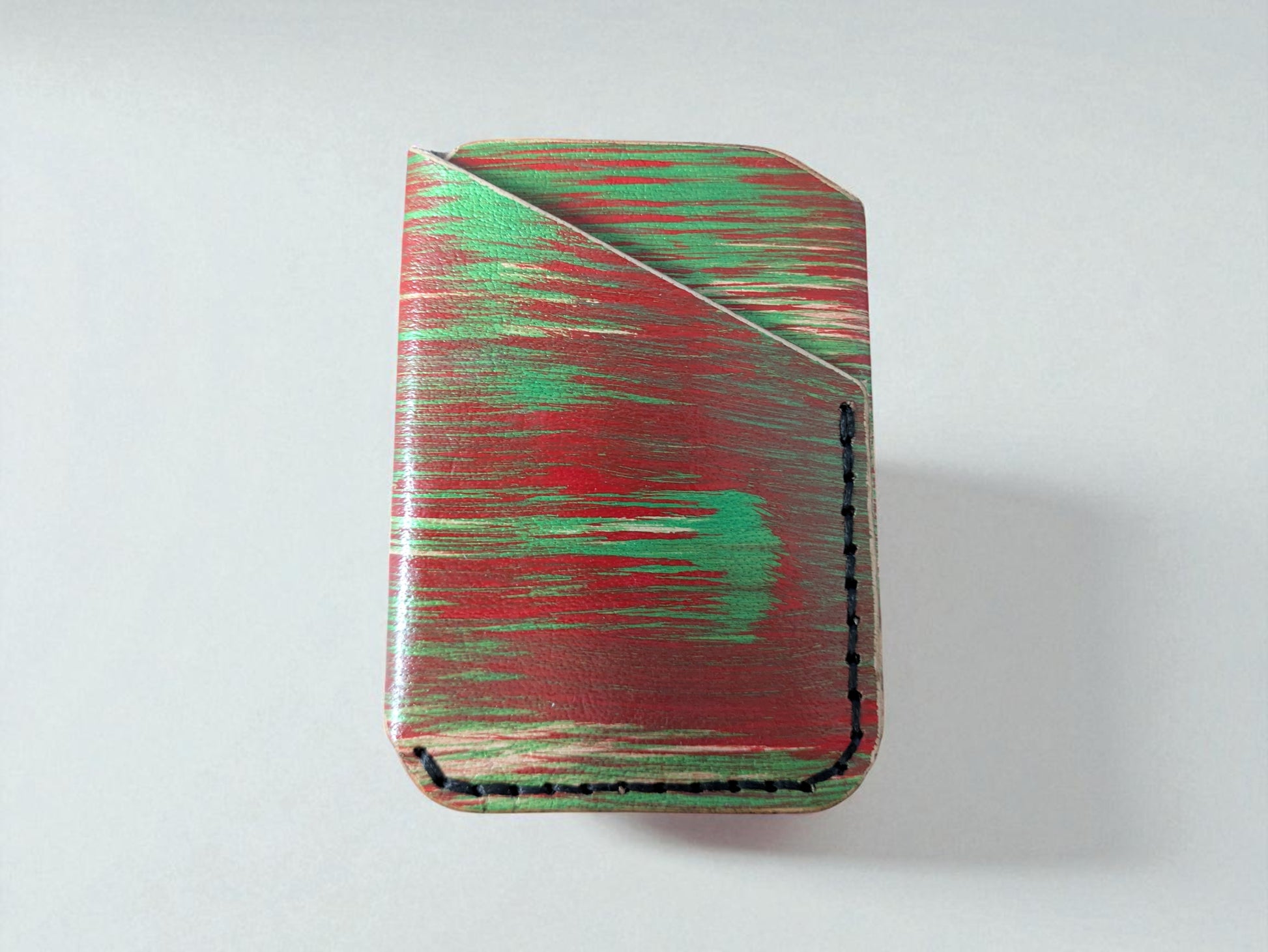 Rectangular cardholder with red and green abstract pattern on a white background