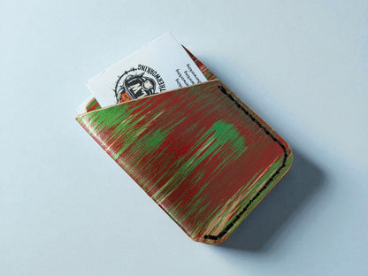 Handmade leather wallet with green accents on a light blue background