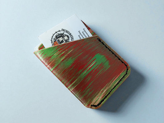 Handmade leather wallet with green accents on a light blue background