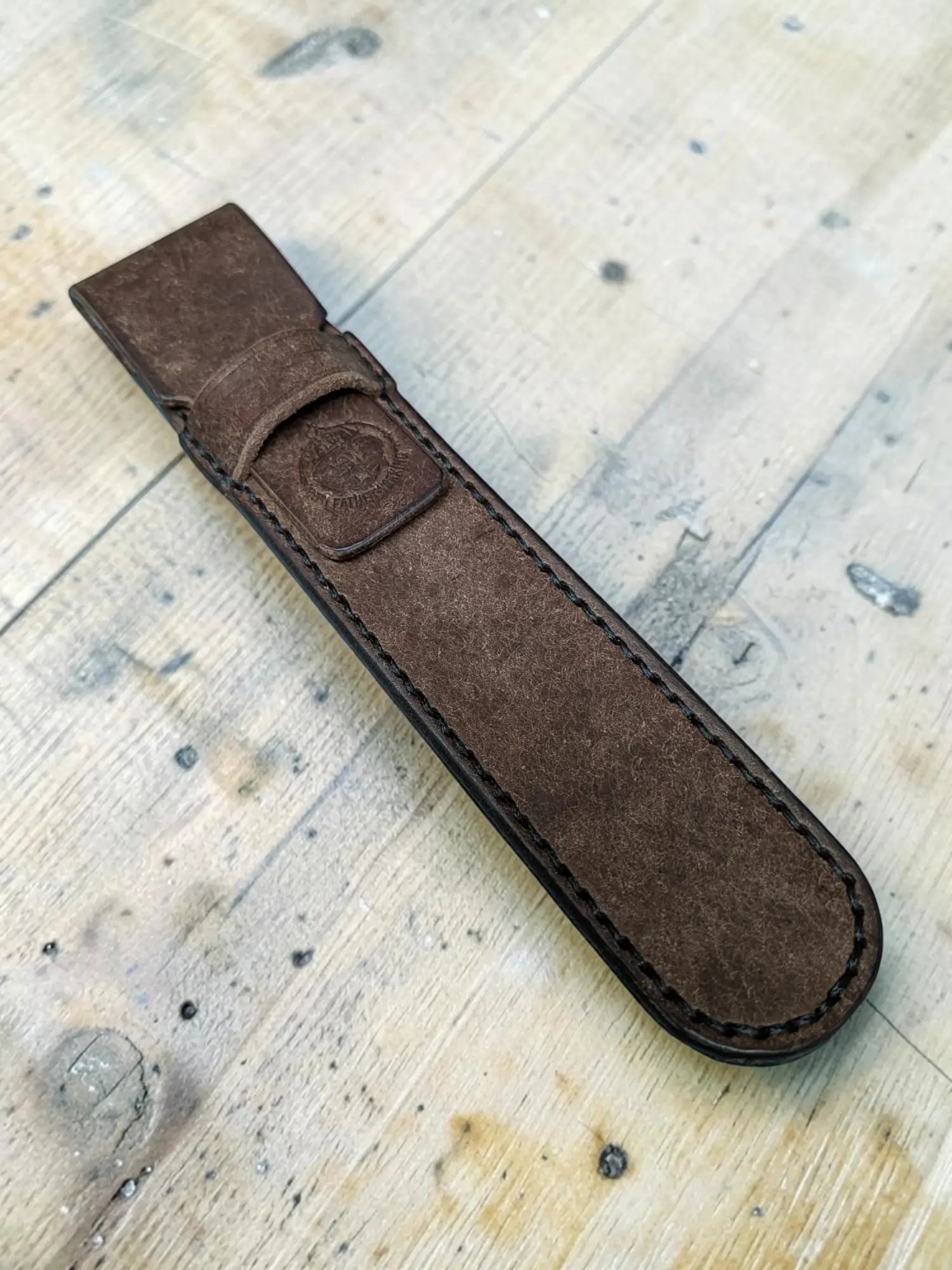 LwLeatherworking dark brown full grain leather pen holder with stitched edges and a small embossed logo.