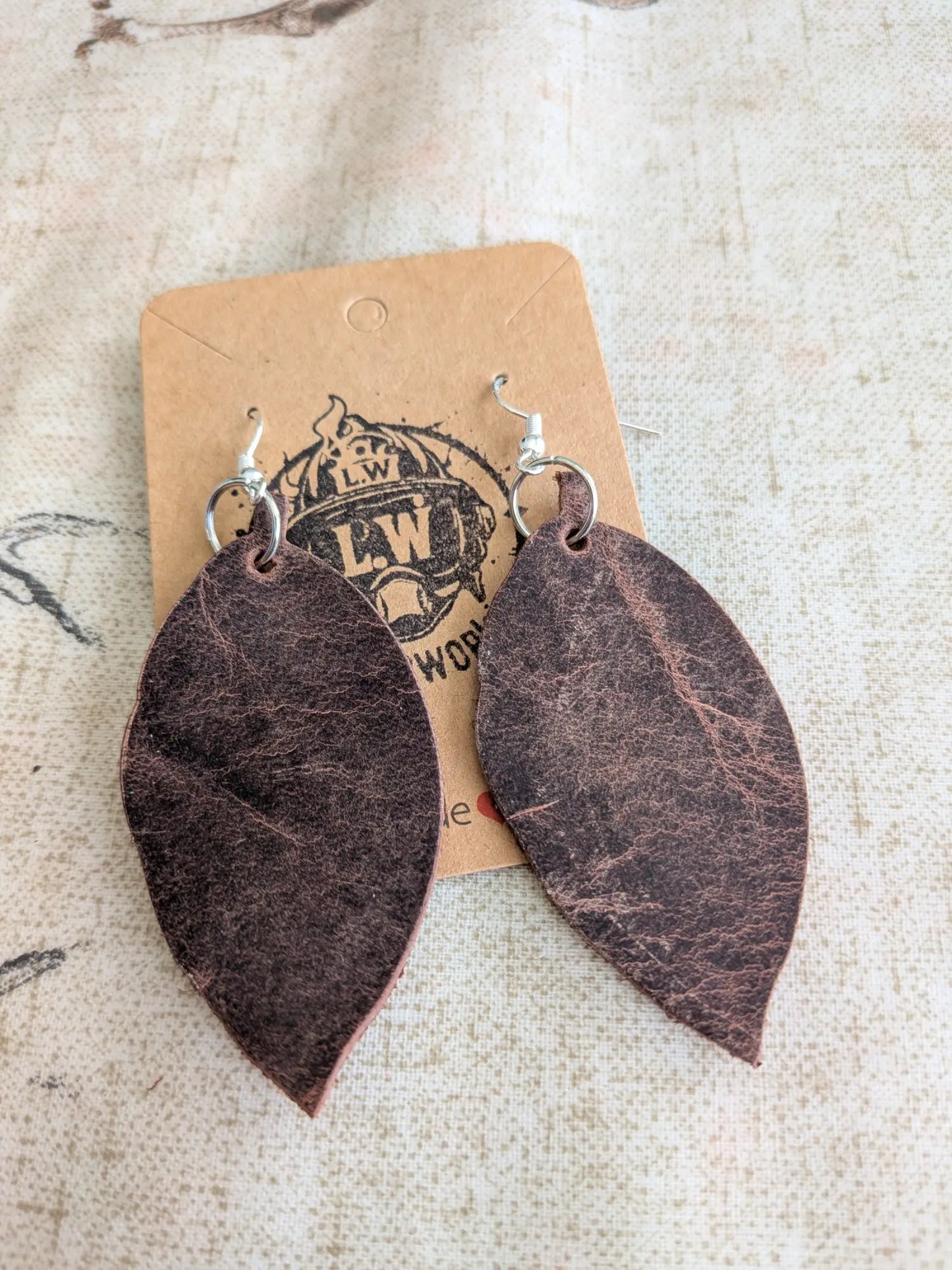 Dark brown leaf-shaped leather earrings with silver hooks made from brown leaf pullup leather