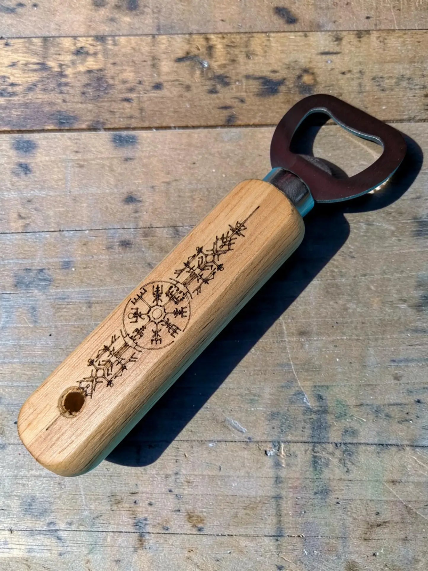 Engraved viking rune wooden bottle opener with dark metal cap featuring intricate norse mythology bar accessory design