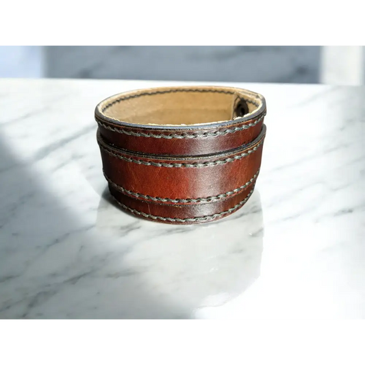 Brown leather cuff bracelet on a marble surface