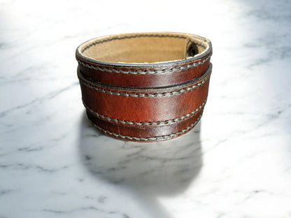Brown full grain leather cuff bracelet on a marble surface