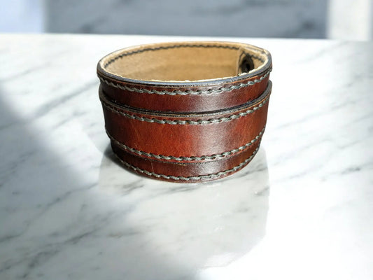 Brown leather cuff bracelet on a marble surface