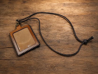 Brown full grain leather id holder with stitched edges and black braided cord lanyard for secure id display