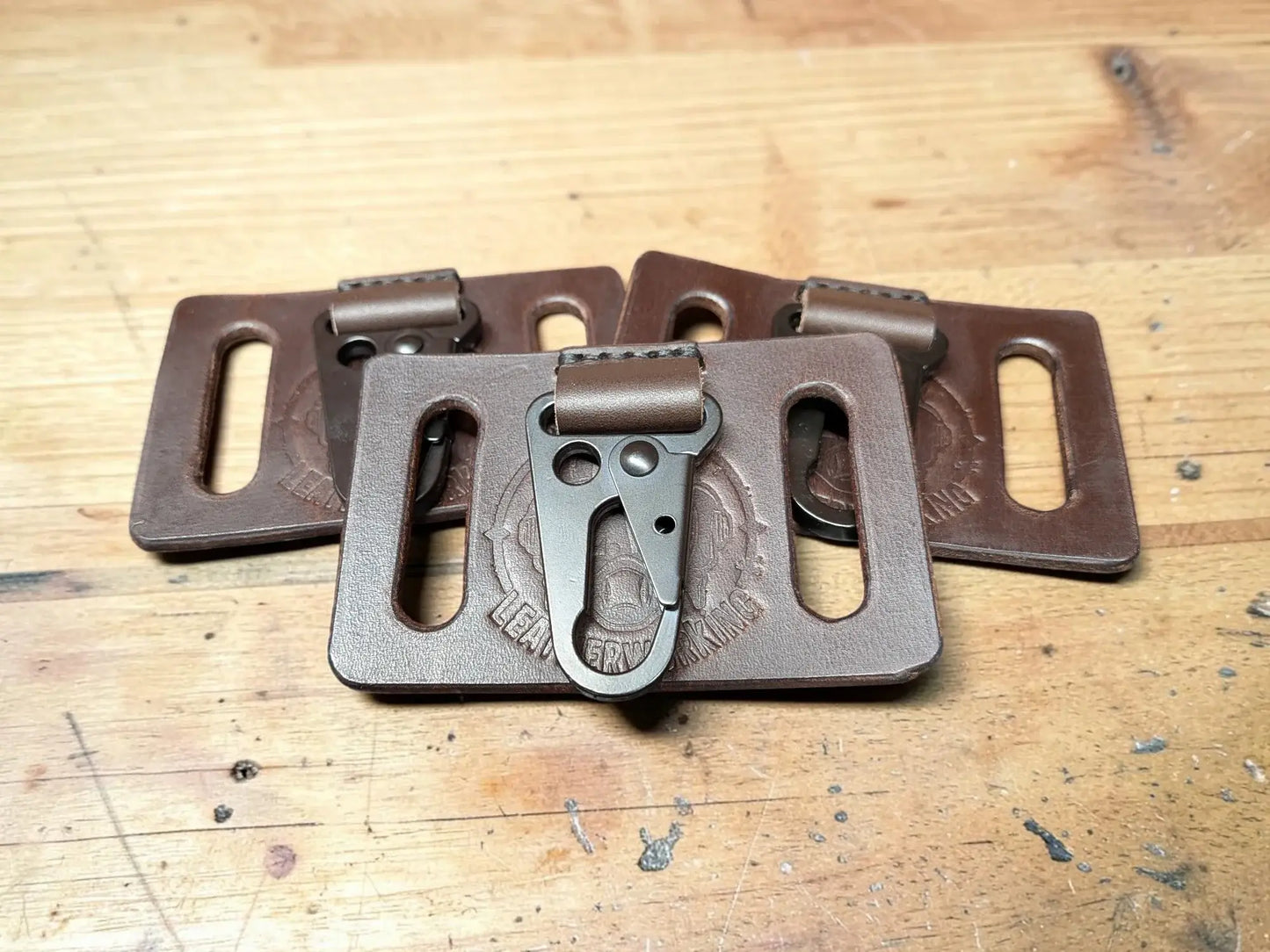 Brown full grain leather key holder with belt clip and metallic carabiner attachment for secure carrying