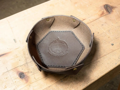 Brown leather hexagonal dish with stitched edges and embossed crest made from vegetable tanned full grain leather