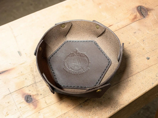 Brown leather hexagonal dish with stitched edges and embossed crest made from vegetable tanned full grain leather