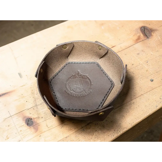 Brown leather hexagonal dish with stitched edges and embossed crest made from vegetable tanned full grain leather