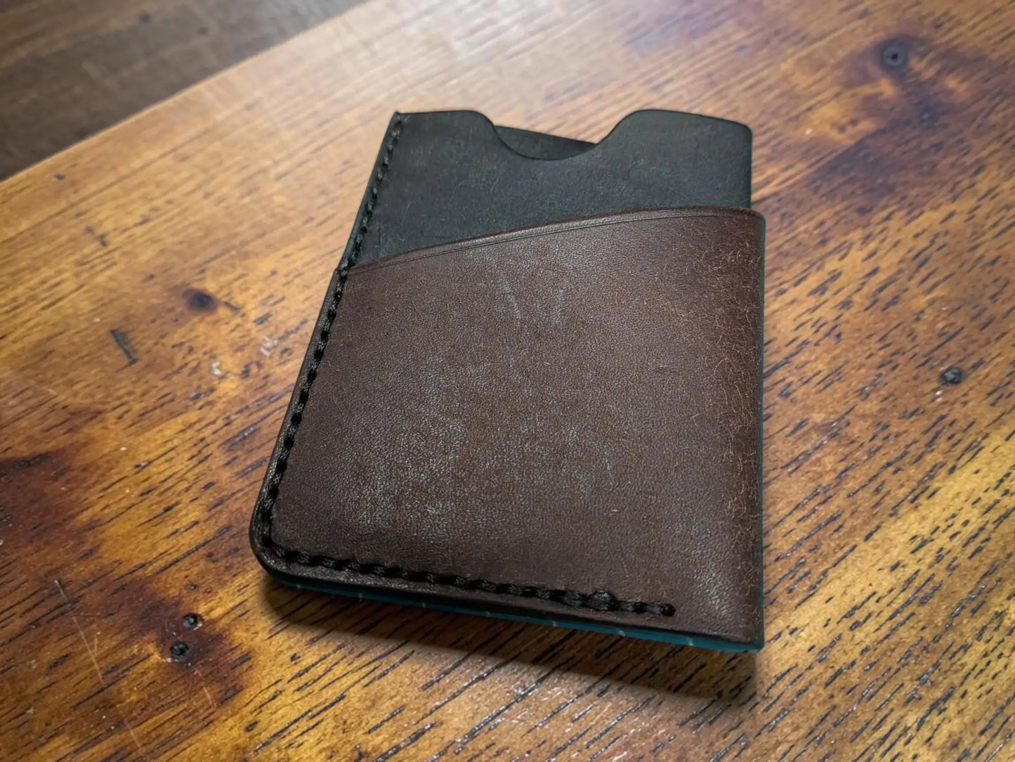 Brown leather kade card holder wallet with black stitching and dark interior made from full grain leather