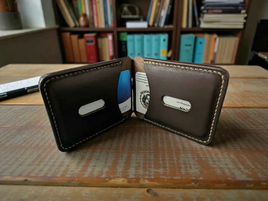 Patriot' Money Clip Wallet - Handmade Minimalist Leather Wallet open on a wooden surface showing a slim, dark brown leather design with stitched edges and card slots holding cards.