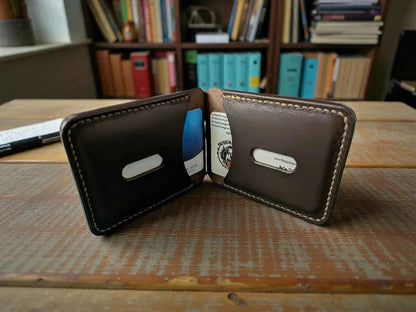 Patriot' Money Clip Wallet - Handmade Minimalist Leather Wallet open on a wooden surface showing a slim, dark brown leather design with stitched edges and card slots holding cards.