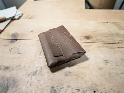 Brown leather stitchless full grain leather card holder with subtle embossed logo on the front