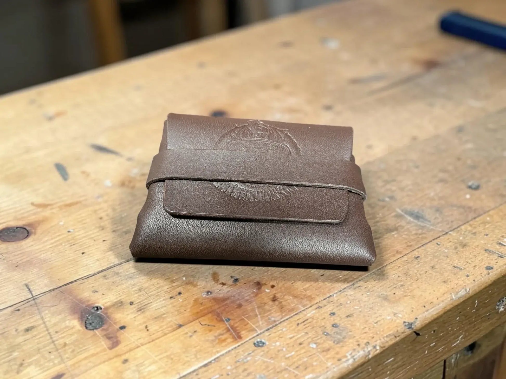 Brown leather stitchless full grain card holder with embossed emblem on the front
