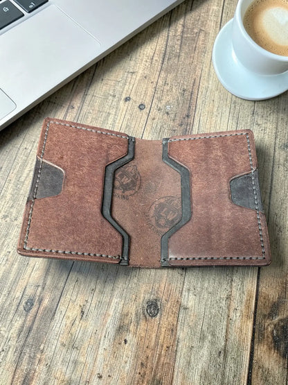 Opened brown leather Venturi wallet showing card slots and embossed logo, flat lay on a wooden desk